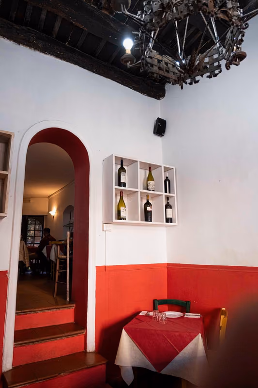 Sala con tavolo apparecchiato e bottiglie di vino