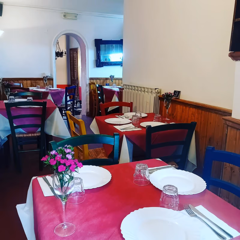 Sala interna dell'osteria con tavoli apparecchiati
