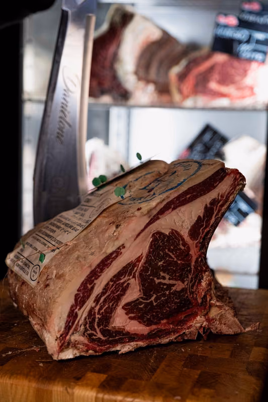 Taglio di carne in frollatura nel frigo dell'osteria