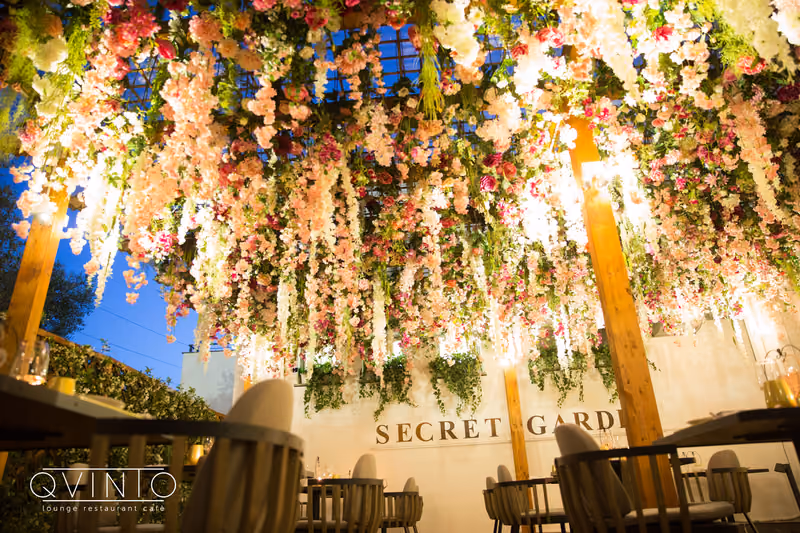Il Secret Garden la sera, con la cascata di fiori sopra i tavoli