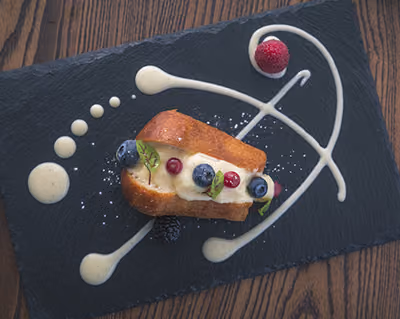 Dolce al piatto con frutti di bosco e decorazioni di crema