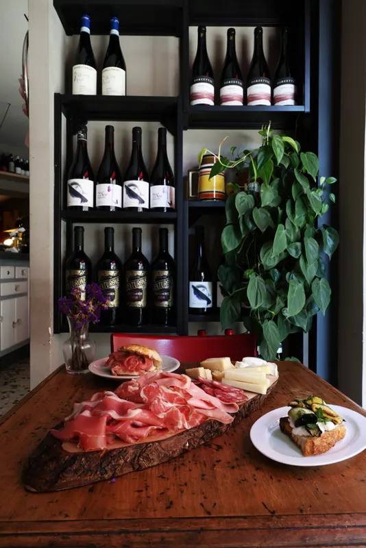 Tagliere davanti alla vetrina dei vini