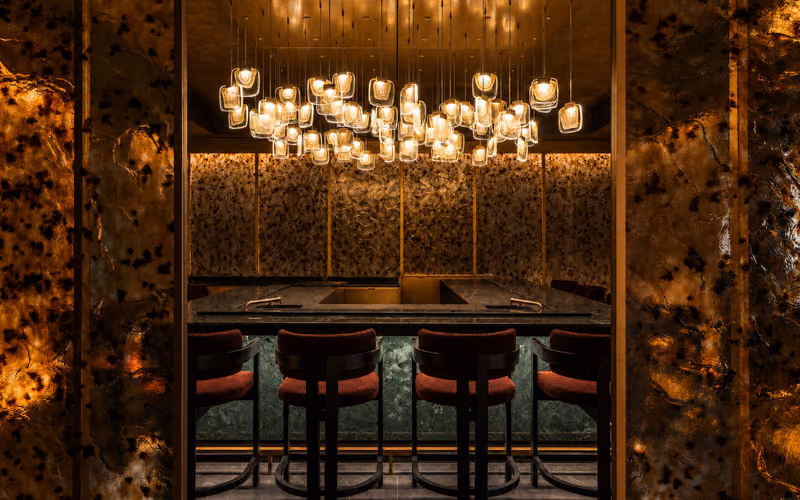 Akira Back Roma, bancone con sgabelli rossi e lampade sospese allo St. Regis Rome