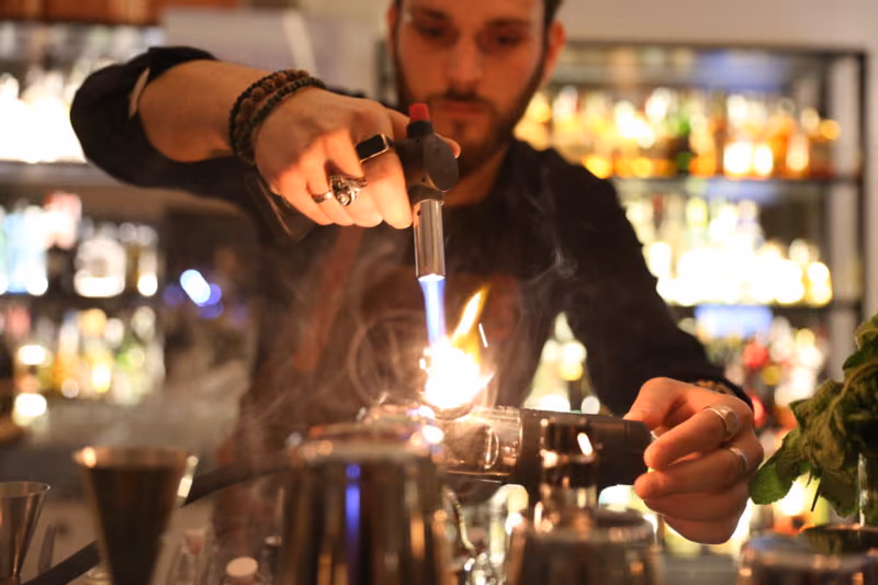 Il bartender prepara un cocktail con la fiamma
