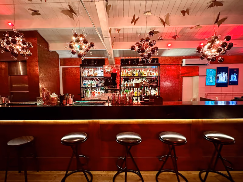Il lungo bancone del cocktail bar visto di fronte