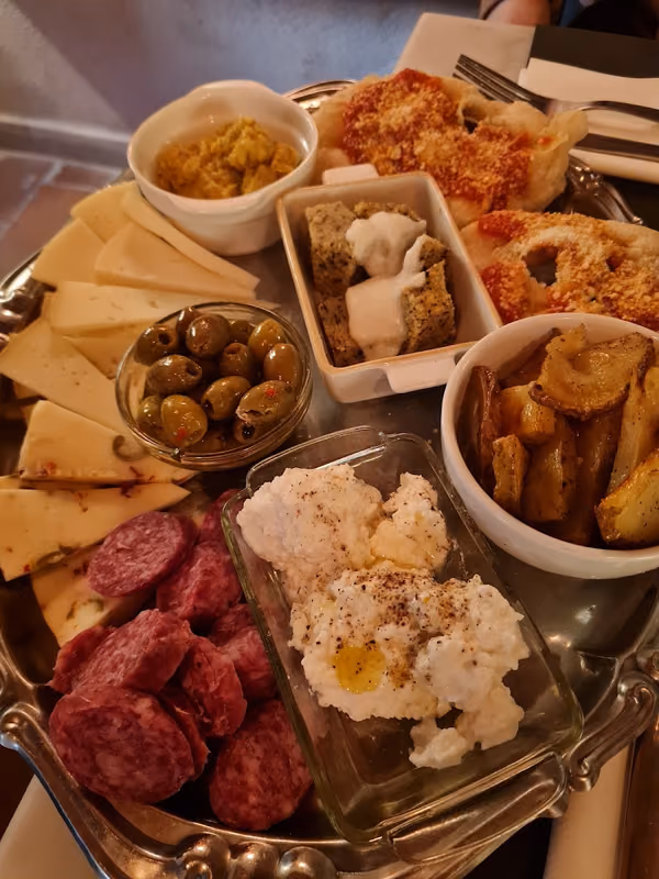 Un tagliere con salumi, formaggi, olive e fritti