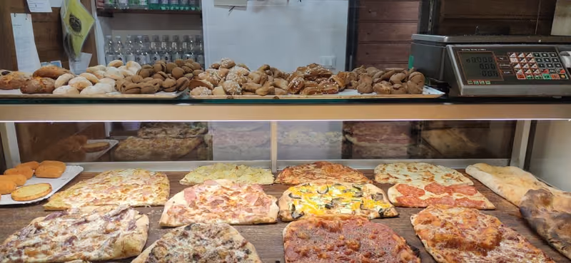 Bancone con pizze al taglio e biscotti
